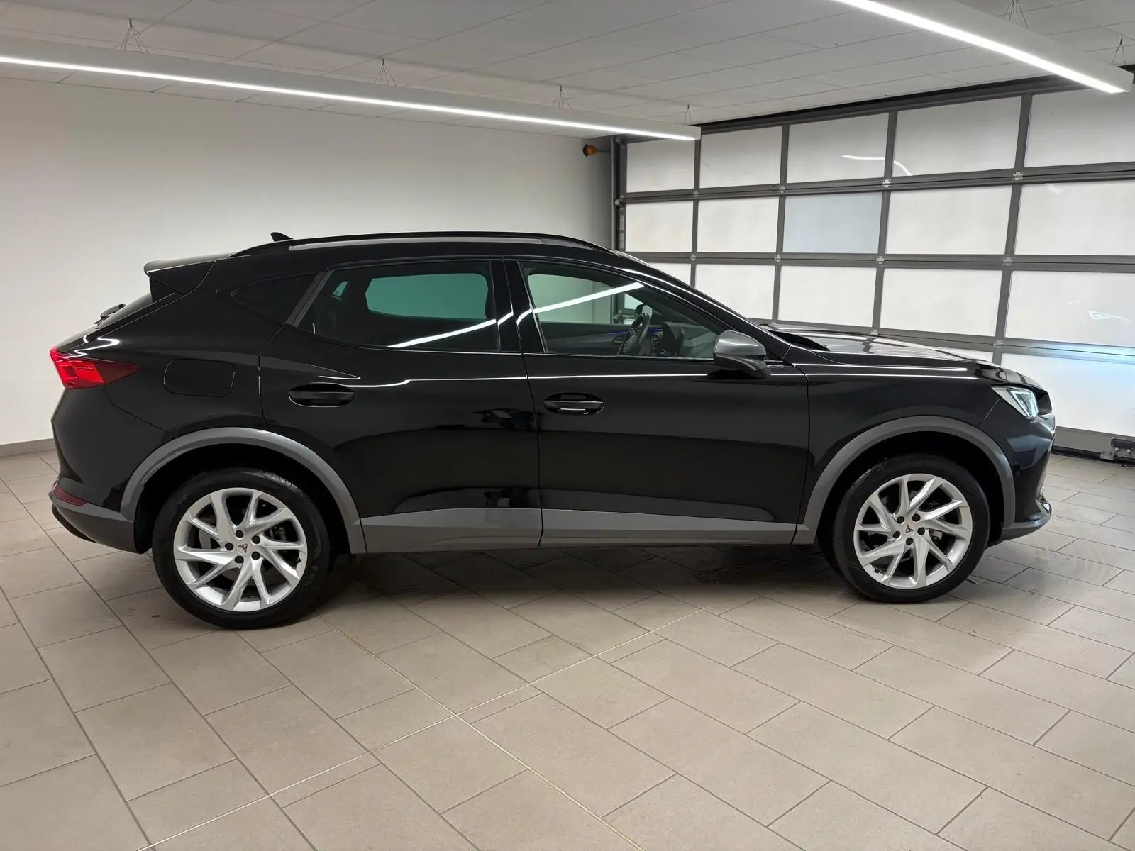 Vue de profil côté gauche du CUPRA Formentor 1.5 TSI 150 DSG7 en noir minuit, avec jantes argentées et détails noirs mats.