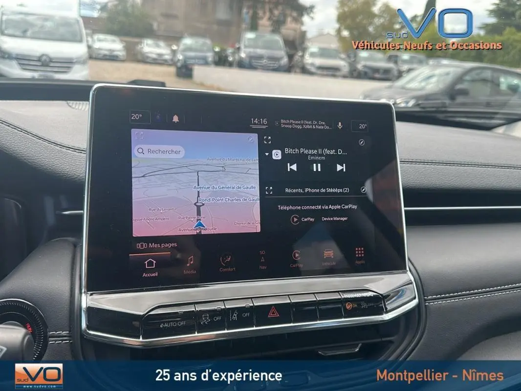 Écran tactile central du tableau de bord du Jeep Compass bleu 2023, affichant navigation et musique en stationnement.