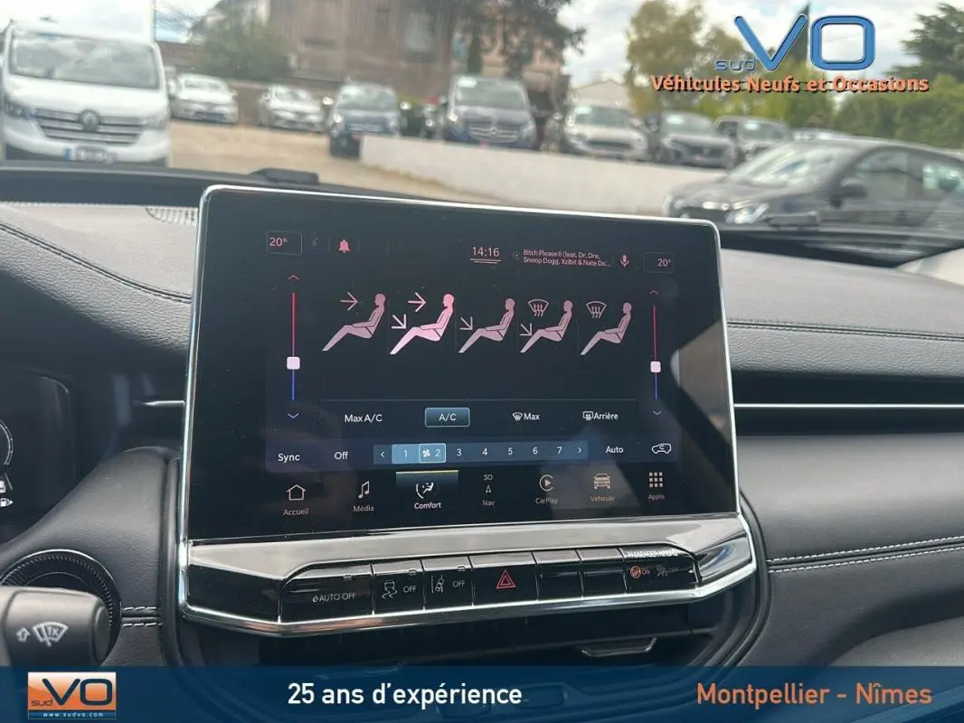 Vue rapprochée de l'écran tactile central du tableau de bord du Jeep Compass bleu 2023 avec commandes climatisation affichées.