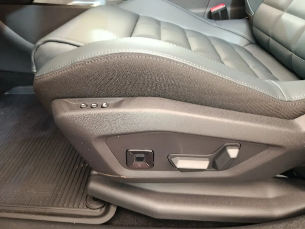 Gros plan sur les commandes de réglage électrique du siège avant gauche en cuir gris foncé du Citroën C5 hybride 2026.