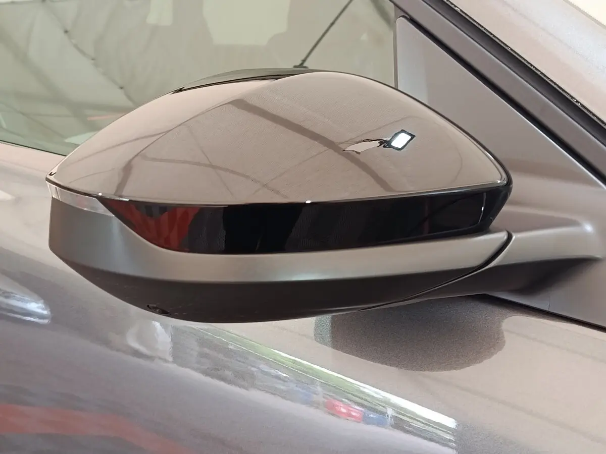 Rétroviseur côté gauche gris foncé de la Citroën C5 Hybride 2026 avec caméra intégrée et finition brillante.