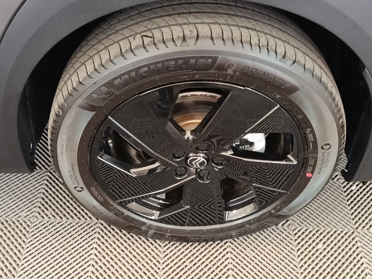 Gros plan sur la roue avant gauche de la Citroën C5 Hybride 2026 avec jante noire brillante et pneu Michelin.