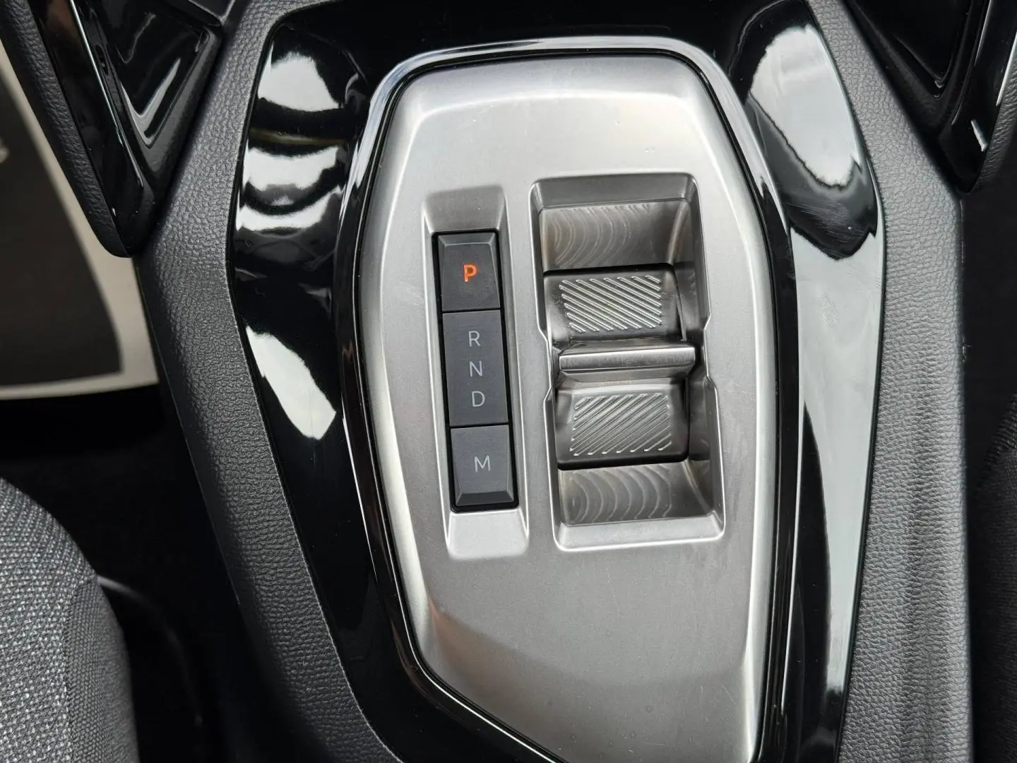 Gros plan sur la console centrale noire et argentée avec sélecteur de boîte auto de la Peugeot 208 1.2 Hybrid 110ch Style.