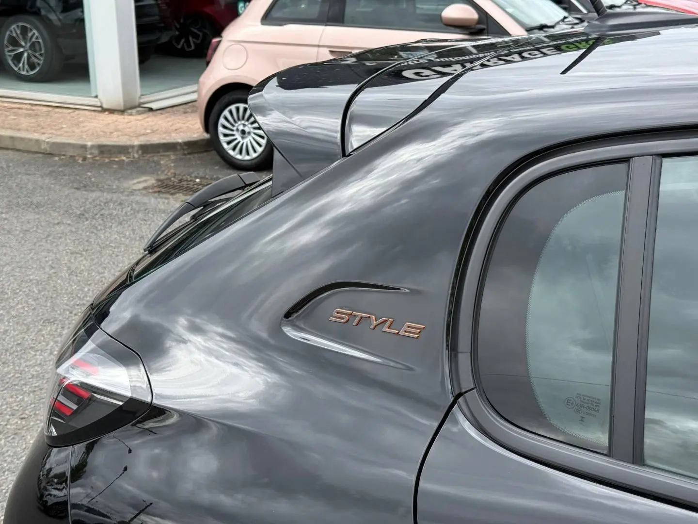 Vue arrière côté droit de la Peugeot 208 noire Perla Nera avec logo Style sur l'aile arrière.