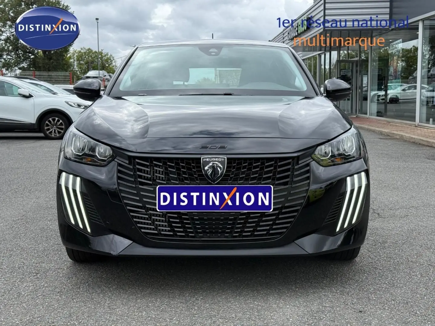 Vue frontale d'une Peugeot 208 noire Perla Nera avec feux LED verticaux distinctifs et calandre noire.