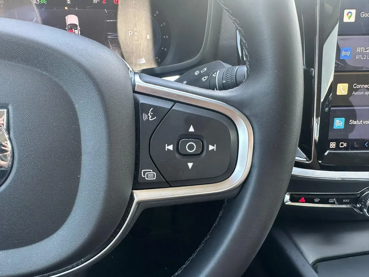 Gros plan sur le volant noir avec commandes intégrées et écran tactile du tableau de bord d'une Volvo S60 Thunder Grey 2024