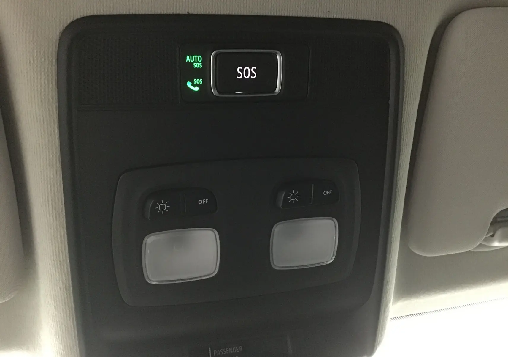 Bouton SOS et commandes d'éclairage intérieur au plafond d'une Renault Clio V gris schiste, vue en gros plan.