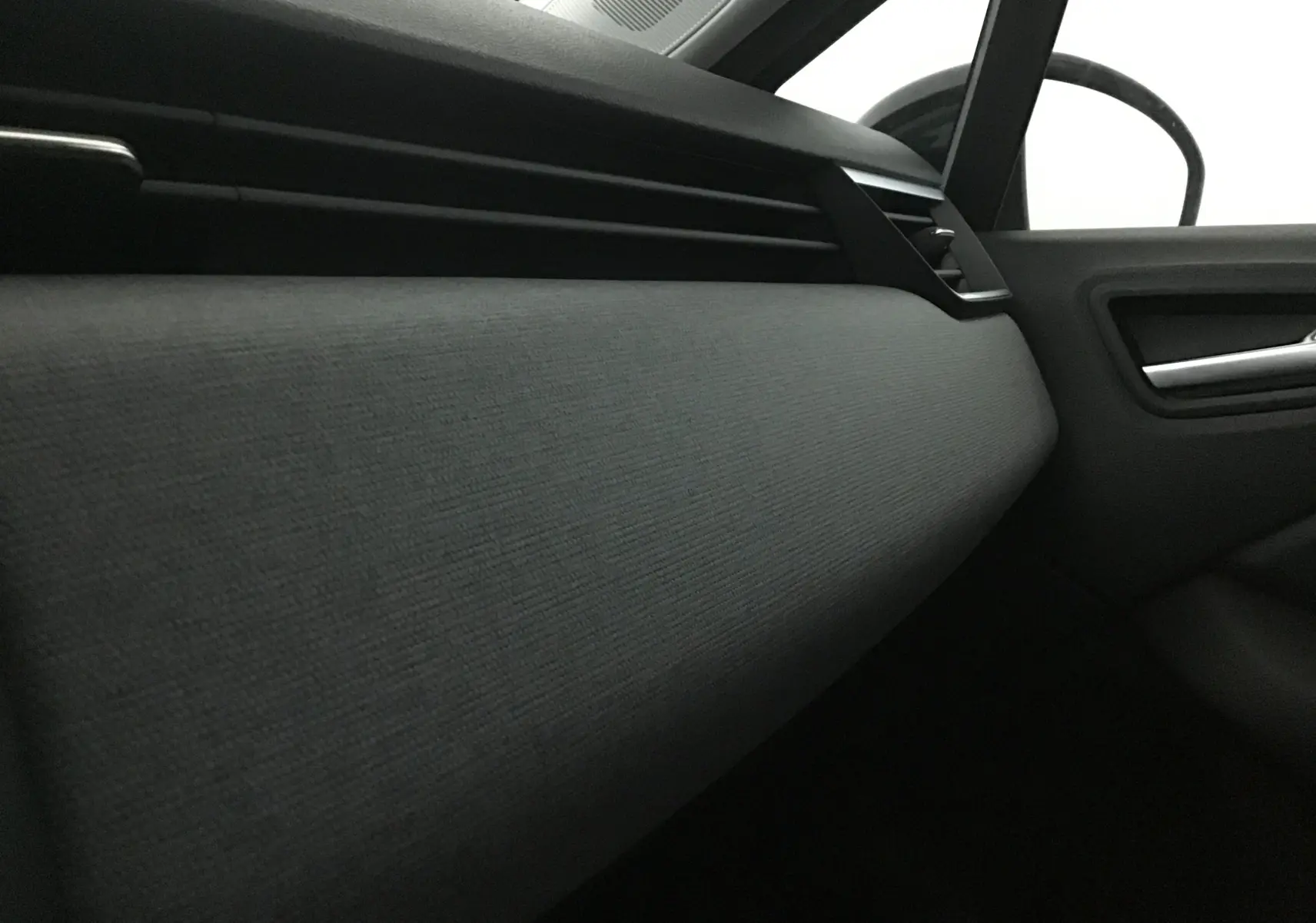 Gros plan sur la garniture grise du tableau de bord côté passager de la Renault Clio V 1.5 DCI 100 Evolution.