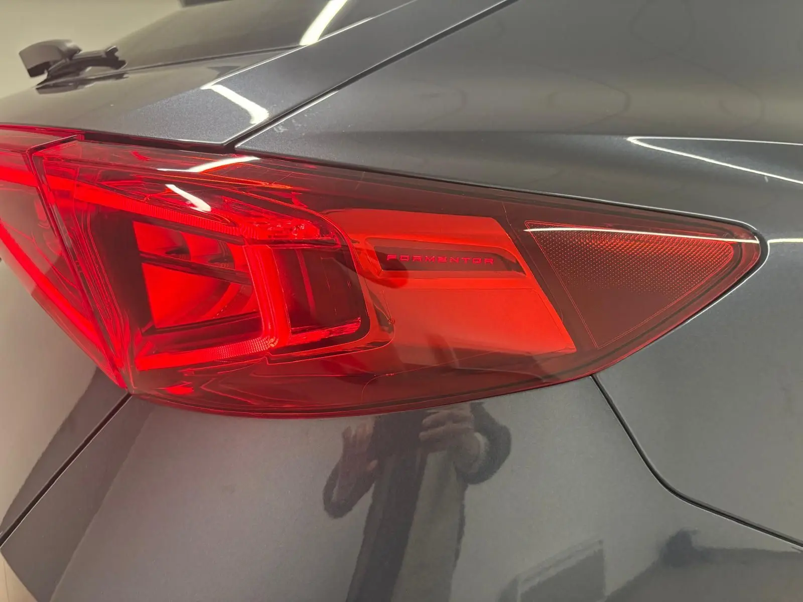 Gros plan sur le feu arrière droit rouge du CUPRA Formentor 2024 en gris magnétique, avec inscription Formentor visible.