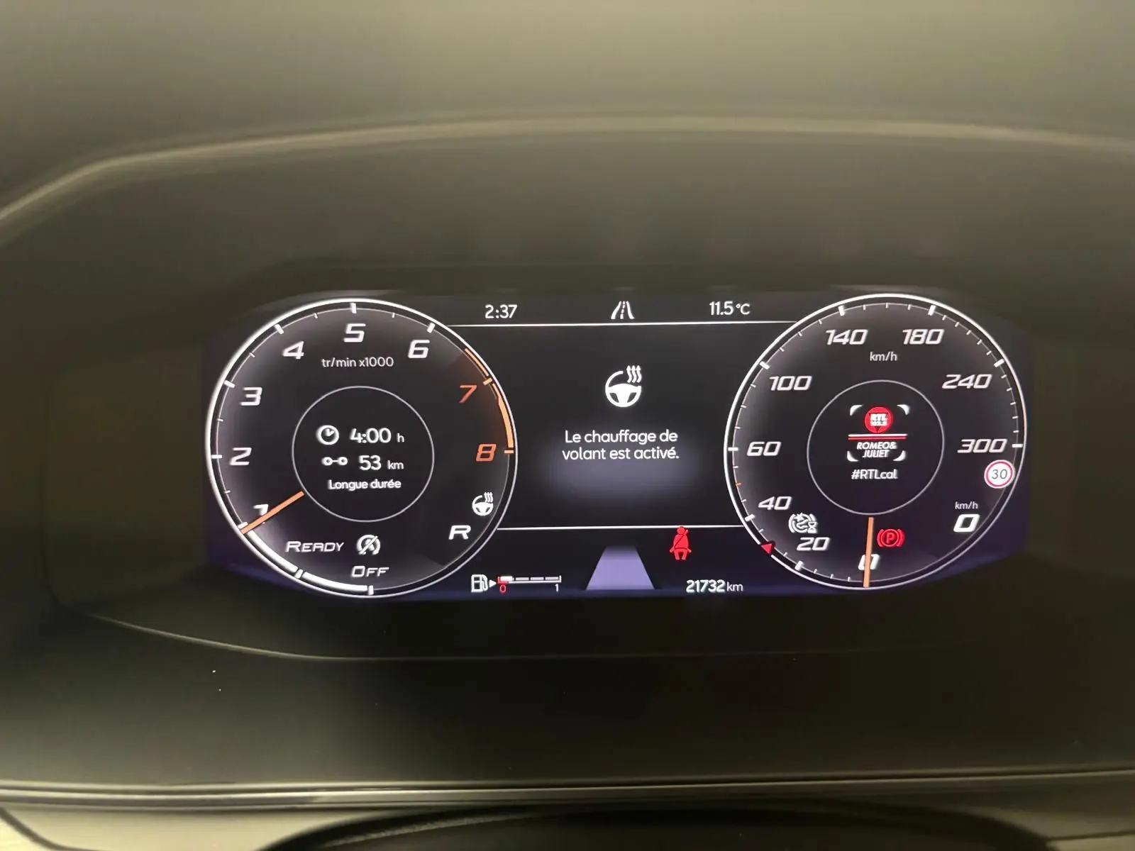 Vue rapprochée du tableau de bord numérique de la CUPRA Formentor gris magnétique, affichant le chauffage du volant activé.