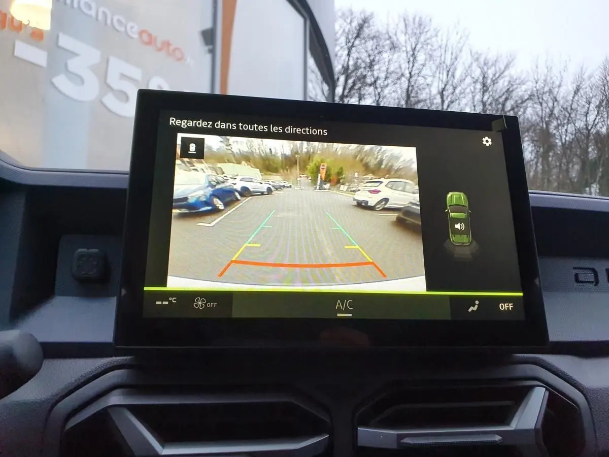Écran central affichant la caméra de recul du Dacia Duster blanc glacier, vue intérieure du tableau de bord.