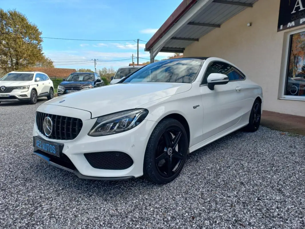 Mercedes Classe C Coupé blanc vue 3/4 avant droit, avec jantes noires et calandre distinctive AMG.