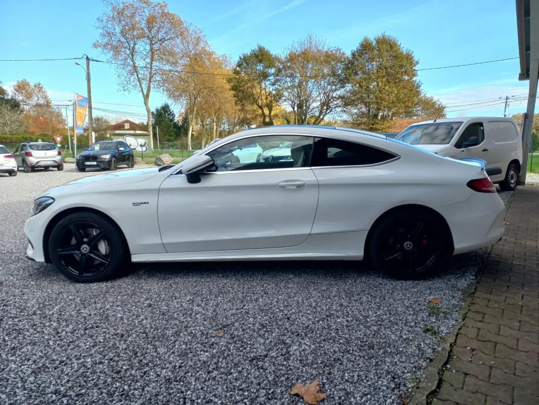Vue de profil côté gauche d'une Mercedes Classe C Coupé blanche avec jantes noires et lignes épurées.