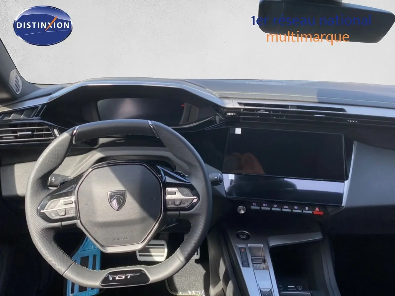 Vue intérieure centrée sur le volant GT et le tableau de bord numérique de la Peugeot 308 Hybrid blanche 2026.
