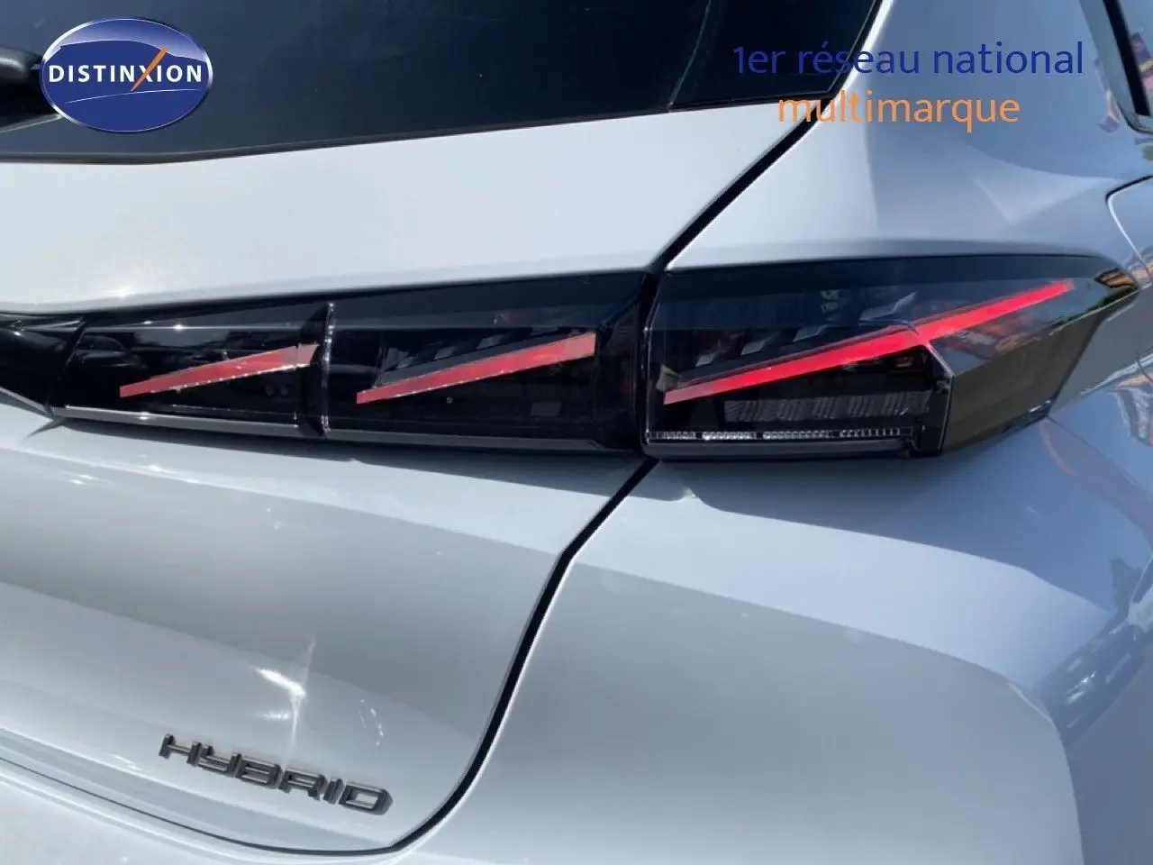 Gros plan sur le feu arrière droit et la malle blanche Okenite métal d’une Peugeot 308 Hybrid 2026.