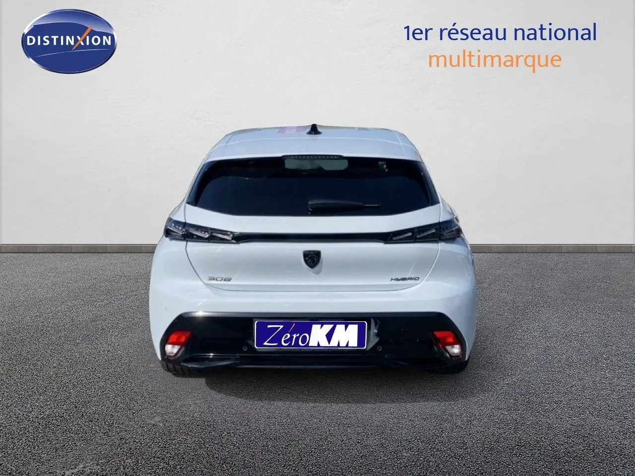 Vue arrière d'une Peugeot 308 Hybrid blanche Okenite Metal avec feux arrière fins et plaque Zero KM.