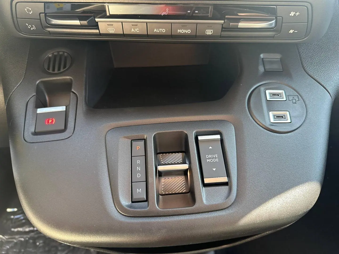 Vue rapprochée de la console centrale noire du Citroën Berlingo 2026 avec commandes boîte auto et climatisation.