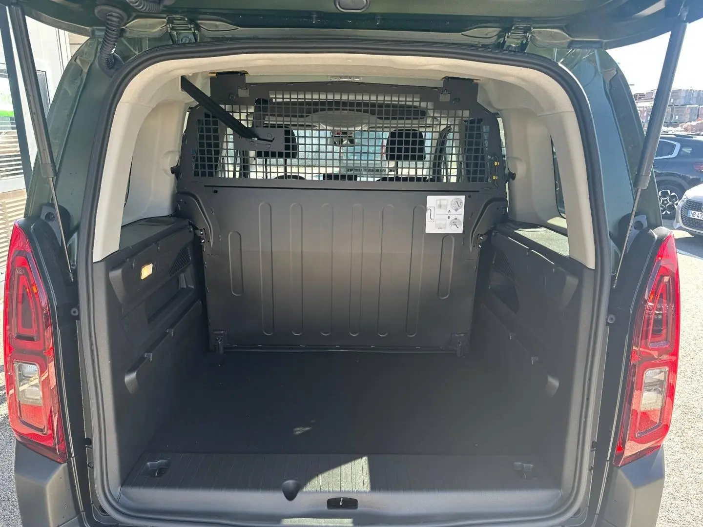 Vue arrière du Citroën Berlingo Sirkka Green avec coffre vide et cloison métallique séparant l'habitacle.
