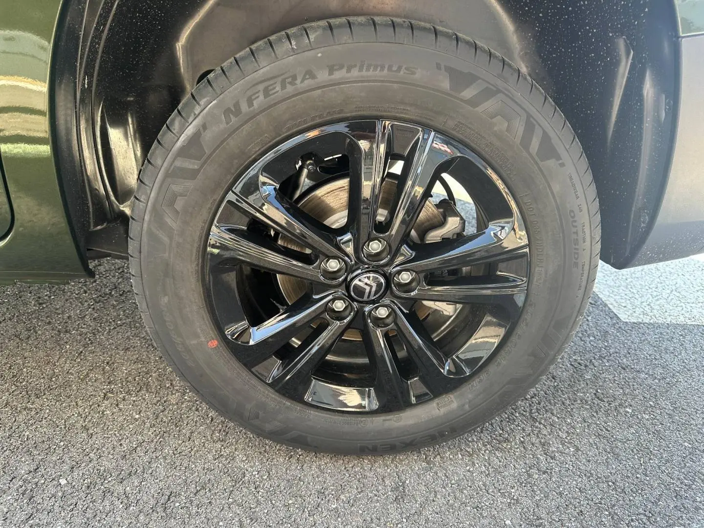 Gros plan sur la roue avant gauche du Citroën Berlingo Sirkka Green avec jante alu noire brillante.