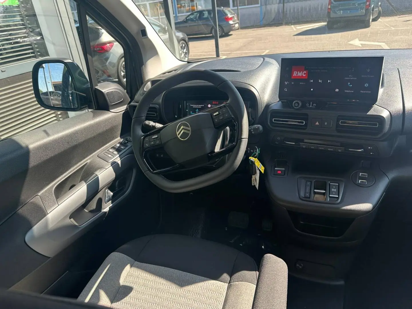 Vue intérieure côté conducteur du Citroën Berlingo 2026, tableau de bord noir avec écran tactile et volant multifonction.