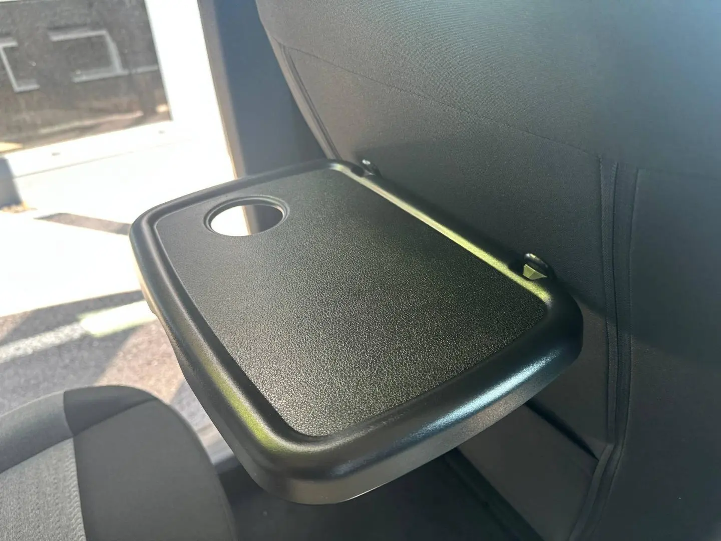 Tablette rabattable noire avec porte-gobelet sur le dossier d’un siège arrière du Citroën Berlingo Sirkka Green.
