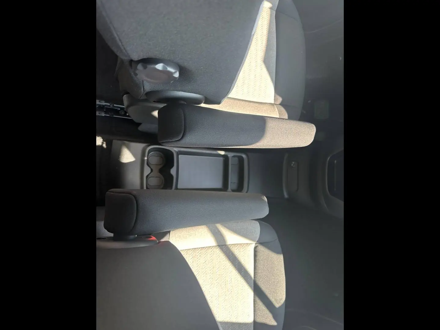 Vue plongeante sur les accoudoirs centraux et sièges arrière gris clair du Citroën Berlingo 2026.