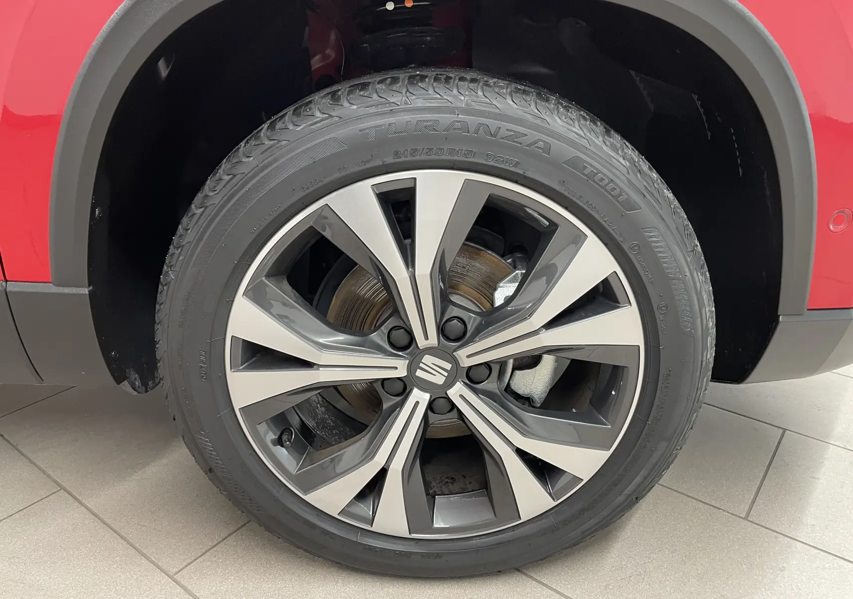 Gros plan sur la jante 18 pouces Performance usinée du côté avant gauche du SEAT Ateca Rouge Velvet 2024.