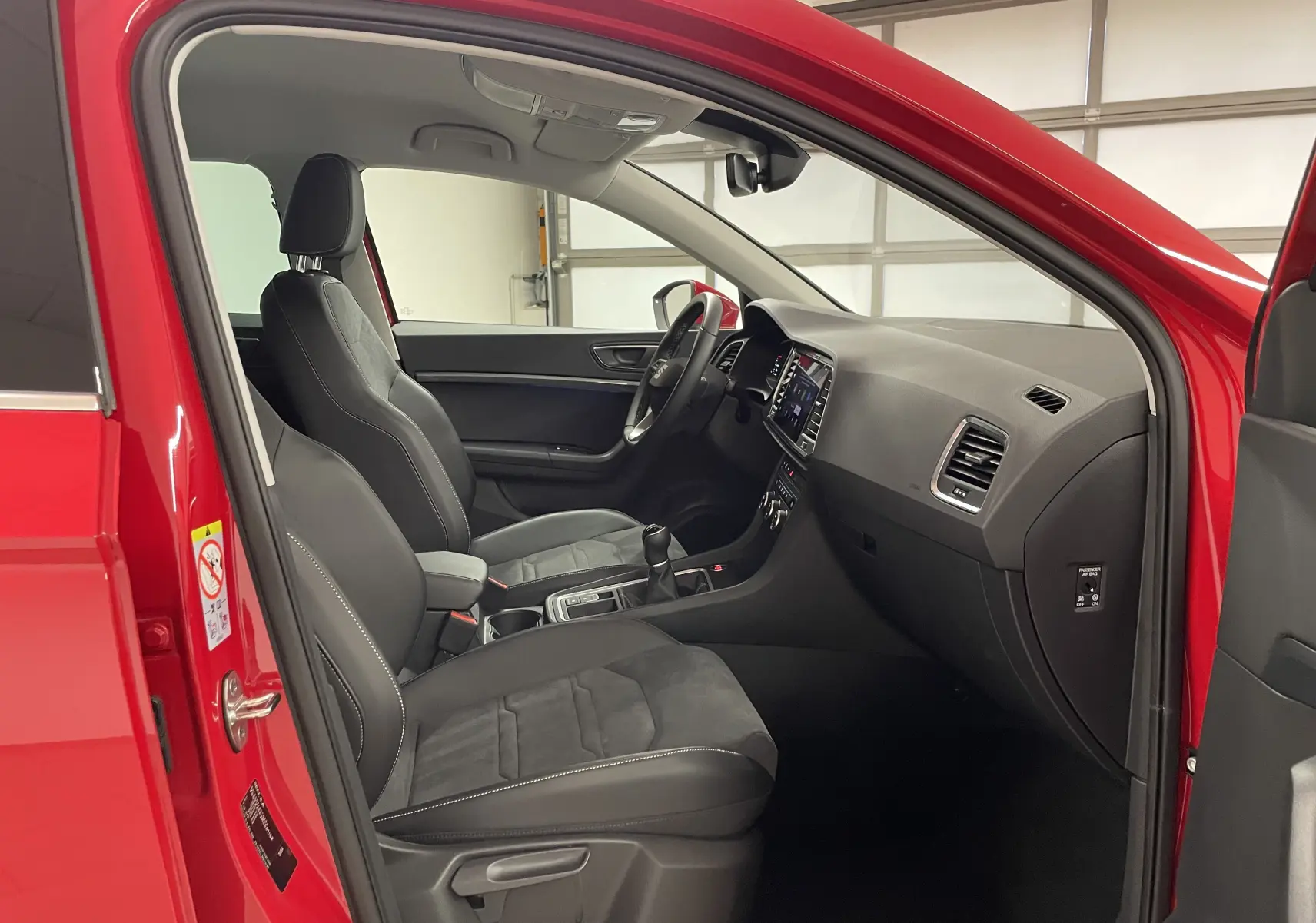 Vue intérieure côté conducteur du SEAT Ateca Rouge Velvet 2024, sièges noirs et tableau de bord moderne.