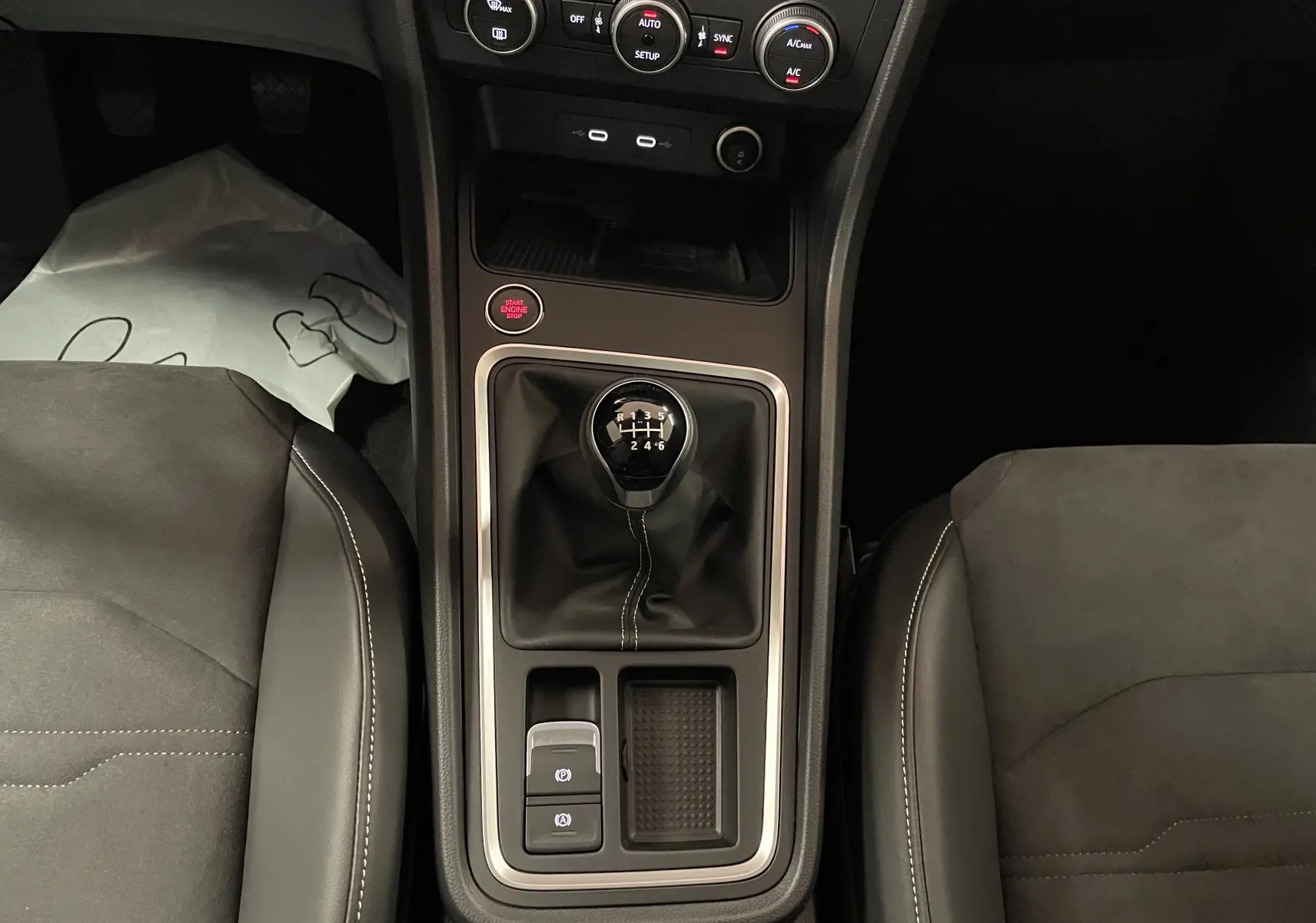 Vue plongeante sur la console centrale du SEAT Ateca 2024, avec levier de vitesse manuel et sièges en tissu noir.