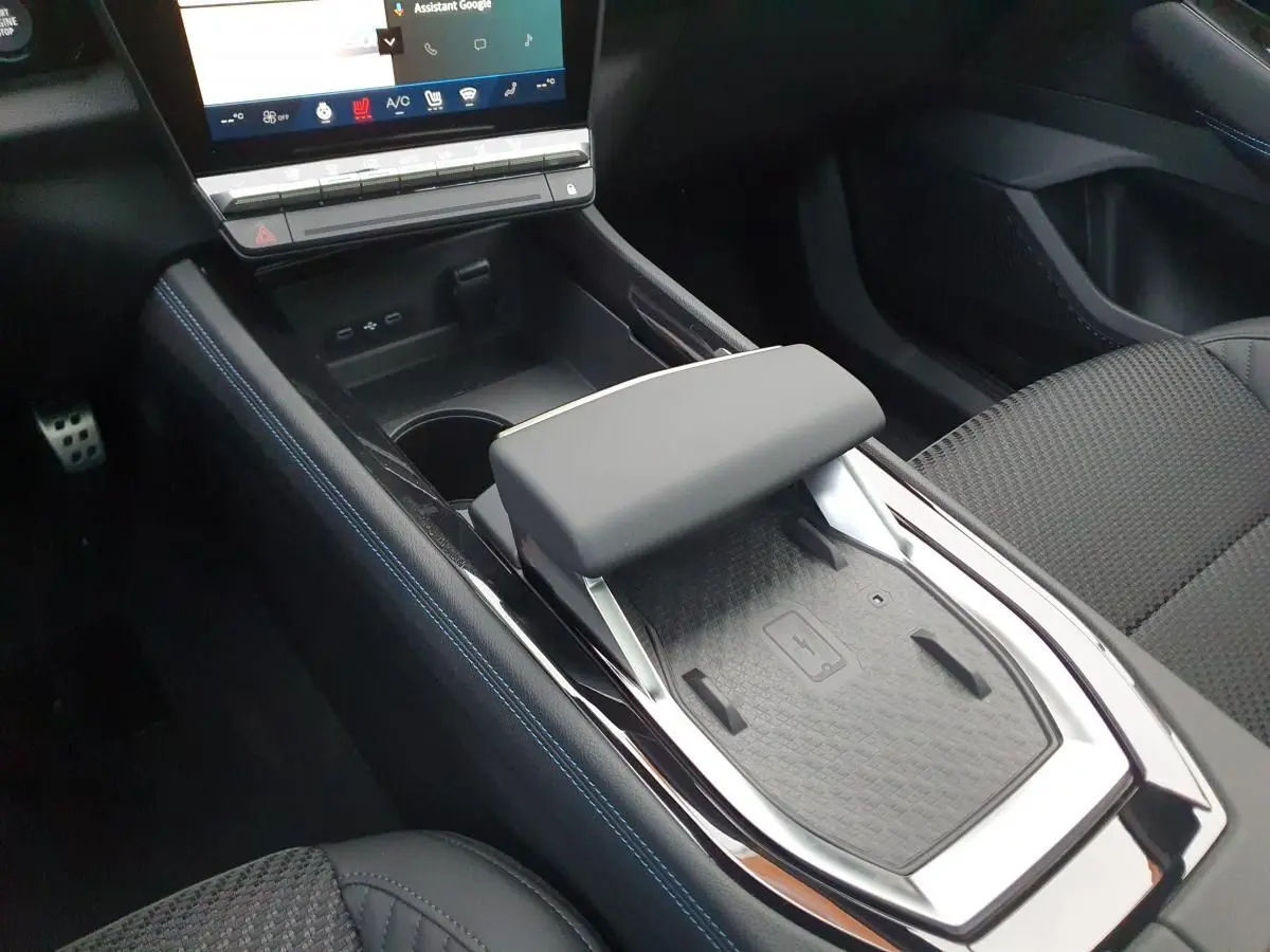 Vue rapprochée de la console centrale avec accoudoir et chargeur à induction du Renault Austral gris schiste.