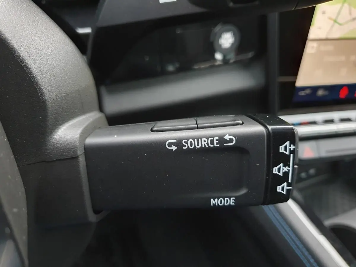 Commande au volant côté gauche du Renault Austral 2025 hybride, avec boutons source et mode visibles.