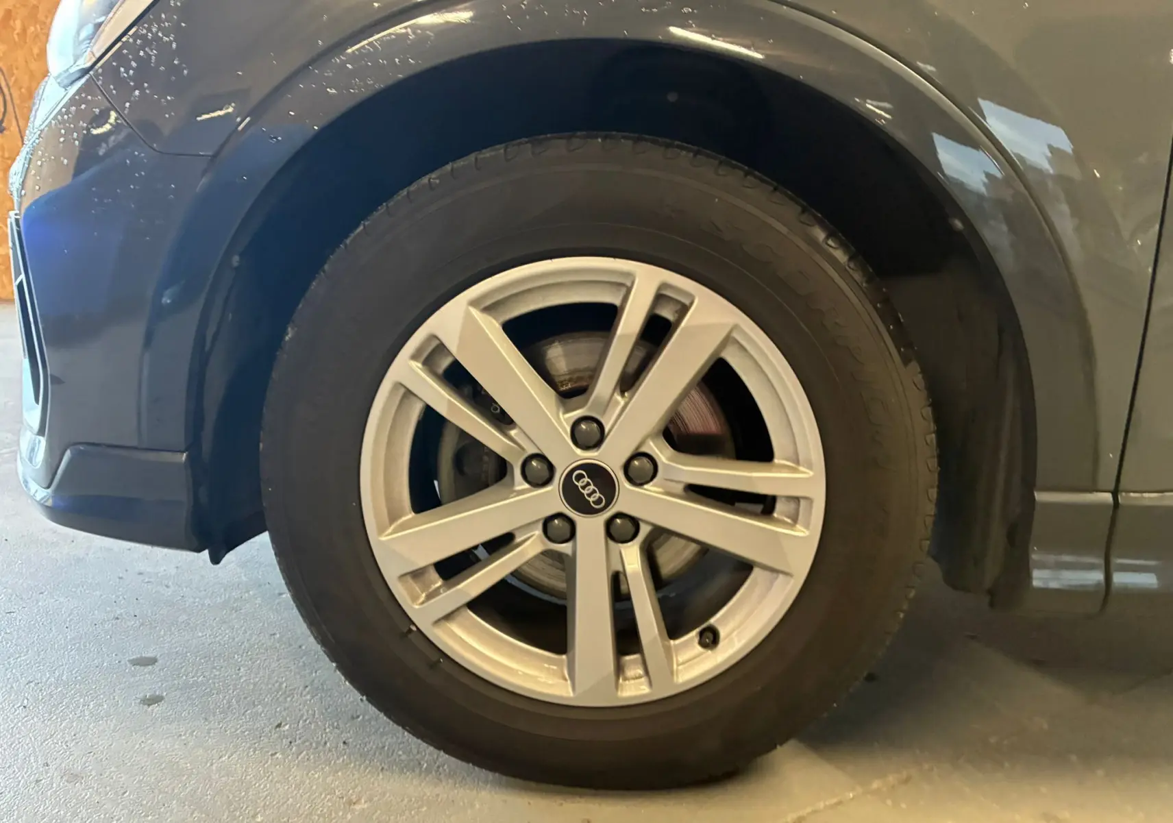 Gros plan sur la roue avant gauche gris métallisé d’un Audi Q3 Sportback avec jante aluminium 5 branches doubles.