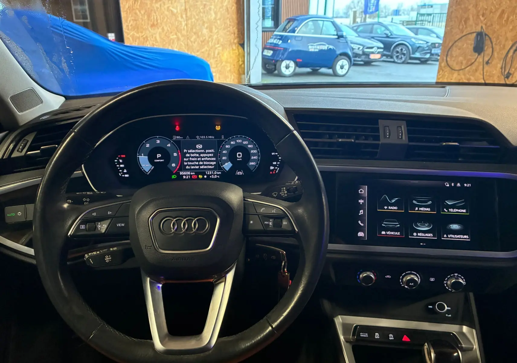 Vue intérieure du tableau de bord et volant noir d'un Audi Q3 Sportback 2021 avec écran tactile et affichage numérique.