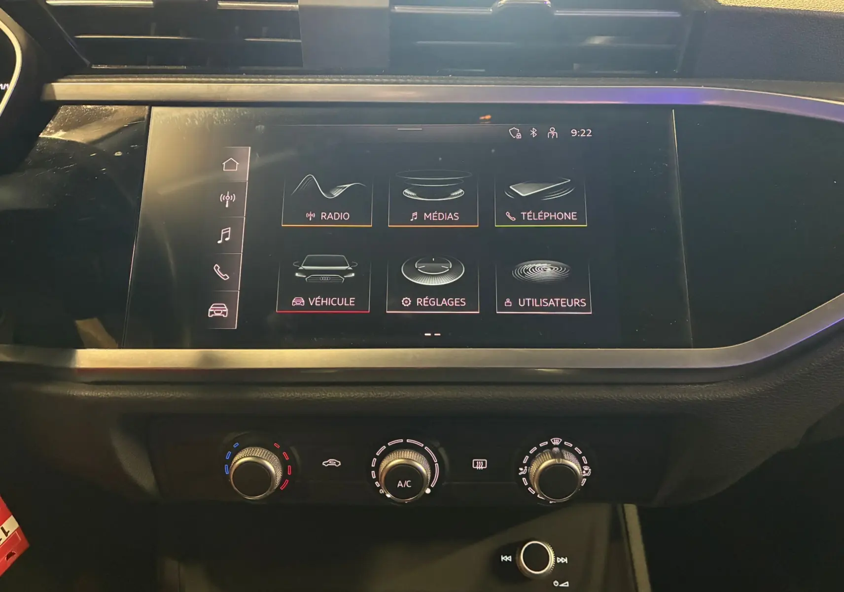 Écran tactile central de l'Audi Q3 Sportback 2021 affichant le menu principal avec commandes climatisation en dessous.