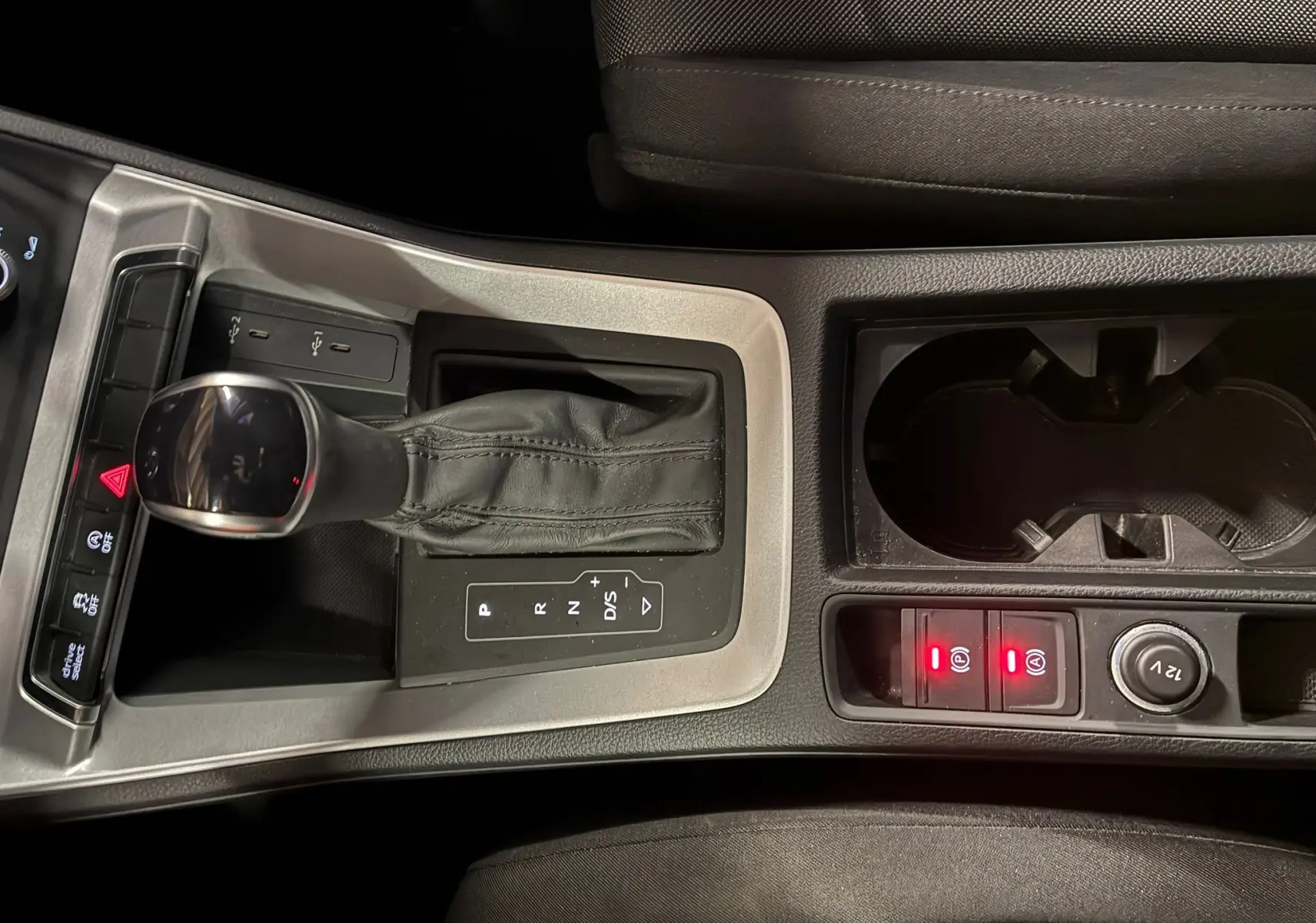 Vue rapprochée de la console centrale de l'Audi Q3 Sportback 2021, avec levier de vitesse cuir et commandes éclairées.