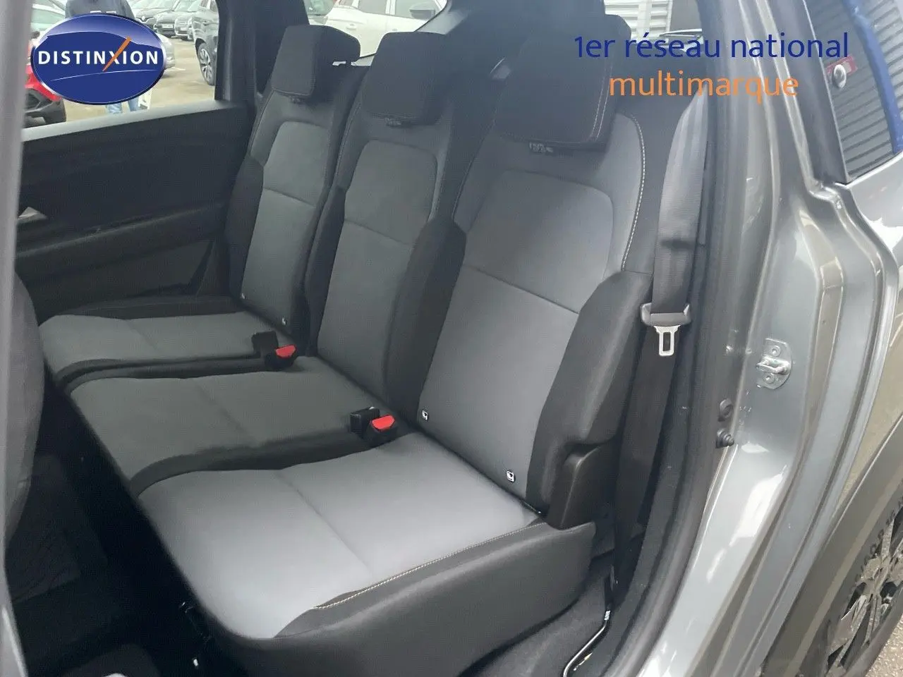 Vue latérale des sièges arrière en tissu gris et noir du Dacia Jogger gris schiste métal, avec ceinture de sécurité visible.