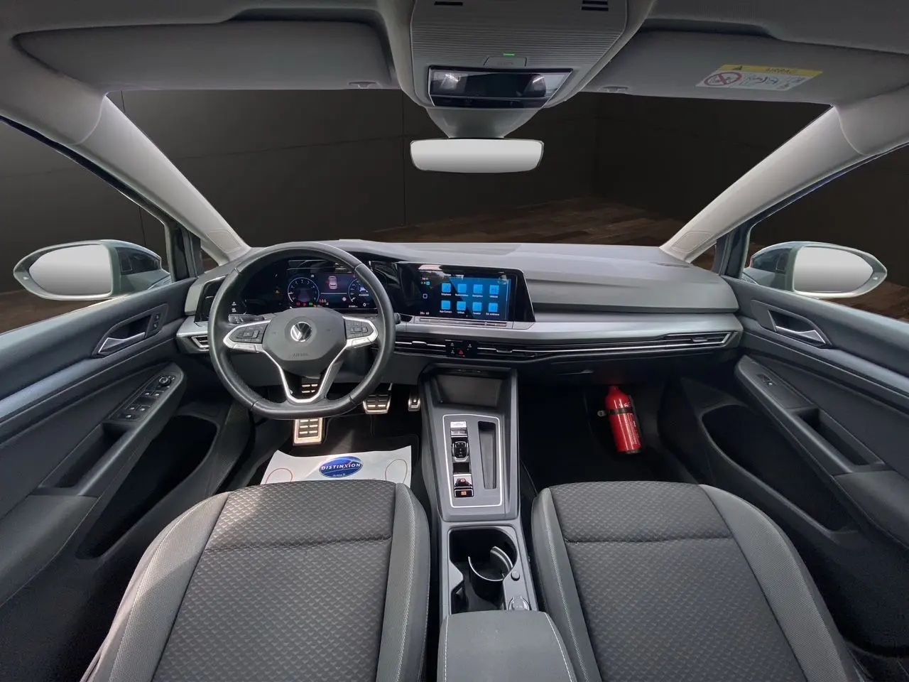 Intérieur noir de la Volkswagen Golf VIII 2022 vu de face, avec tableau de bord numérique et écran tactile central.