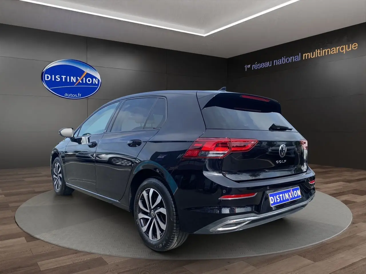 Volkswagen Golf VIII noire vue 3/4 arrière droit, avec vitres surteintées et jantes alliage en showroom.