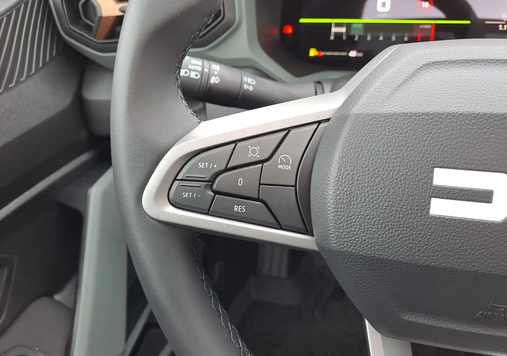 Gros plan sur le volant côté gauche du Dacia Bigster 2025 noir nacré, avec commandes de régulateur de vitesse et tableau de bord numérique.