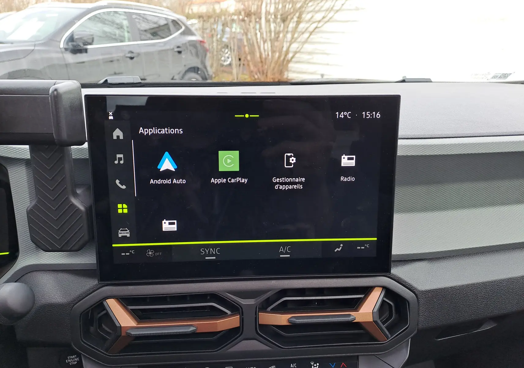 Vue intérieure centrée sur l'écran tactile multimédia du Dacia Bigster noir nacré avec commandes de climatisation en dessous.