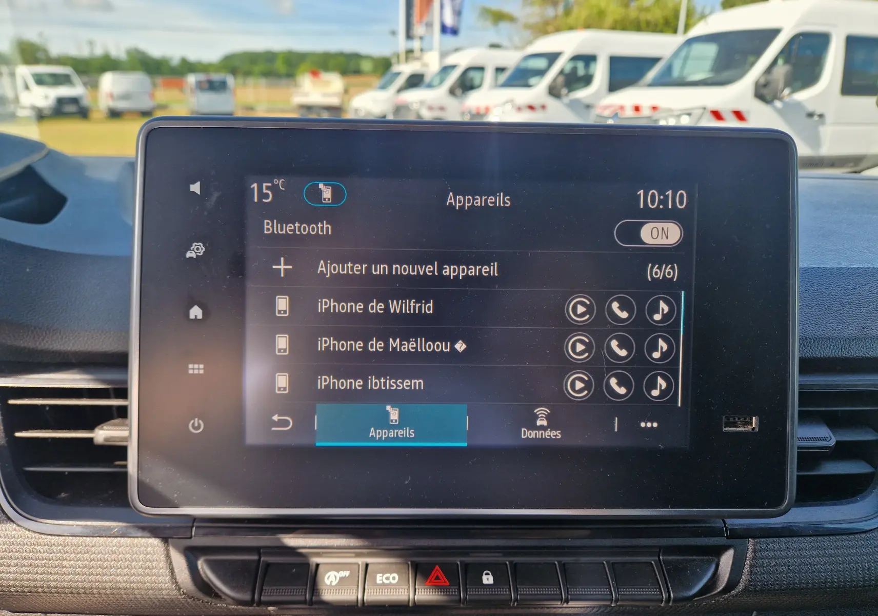 Gros plan sur l'écran tactile central du Renault Kangoo blanc 2023 affichant la connexion Bluetooth et la liste des appareils.