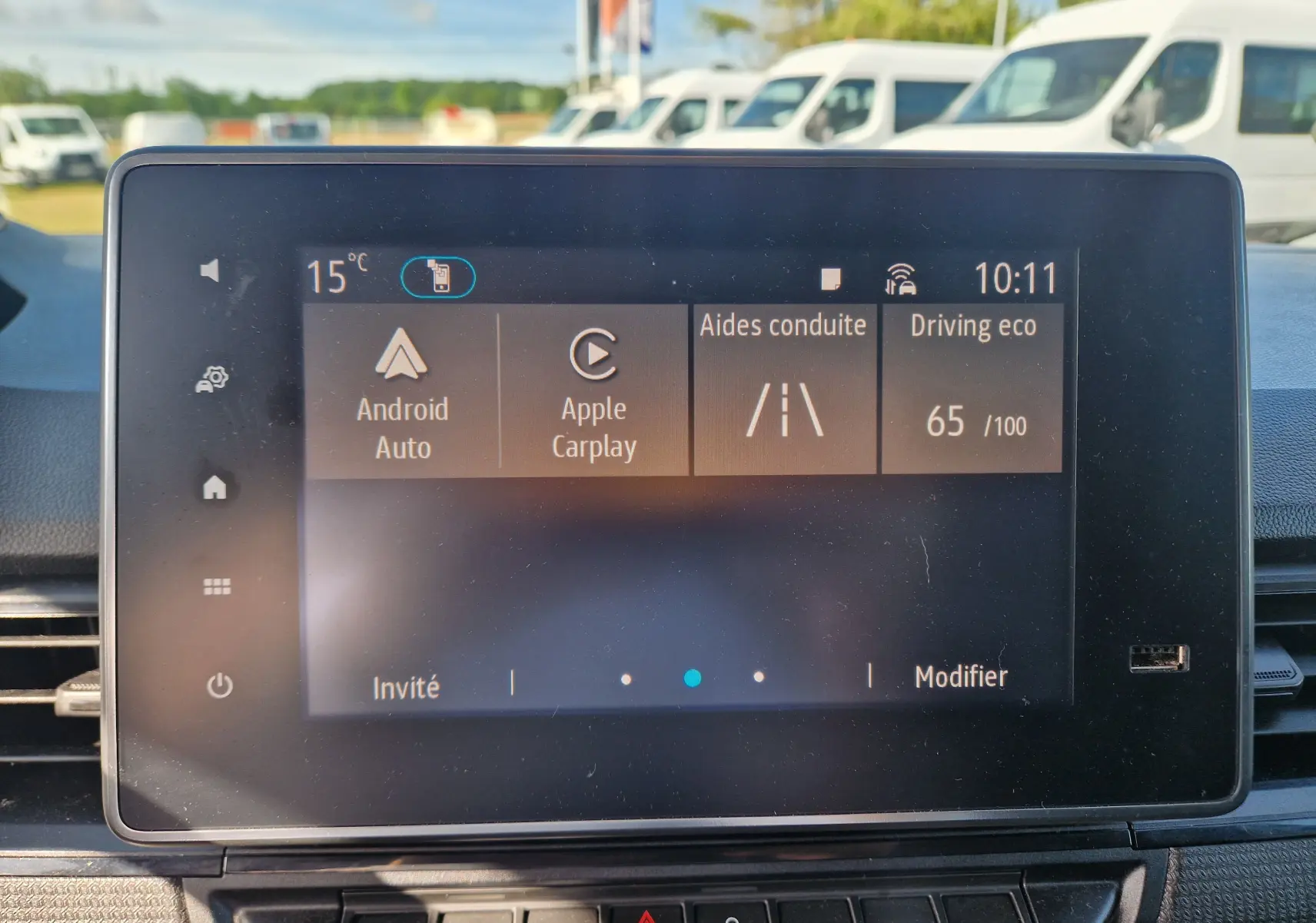 Écran tactile central du Renault Kangoo blanc 2023 affichant les options Android Auto, Apple Carplay et aides à la conduite.