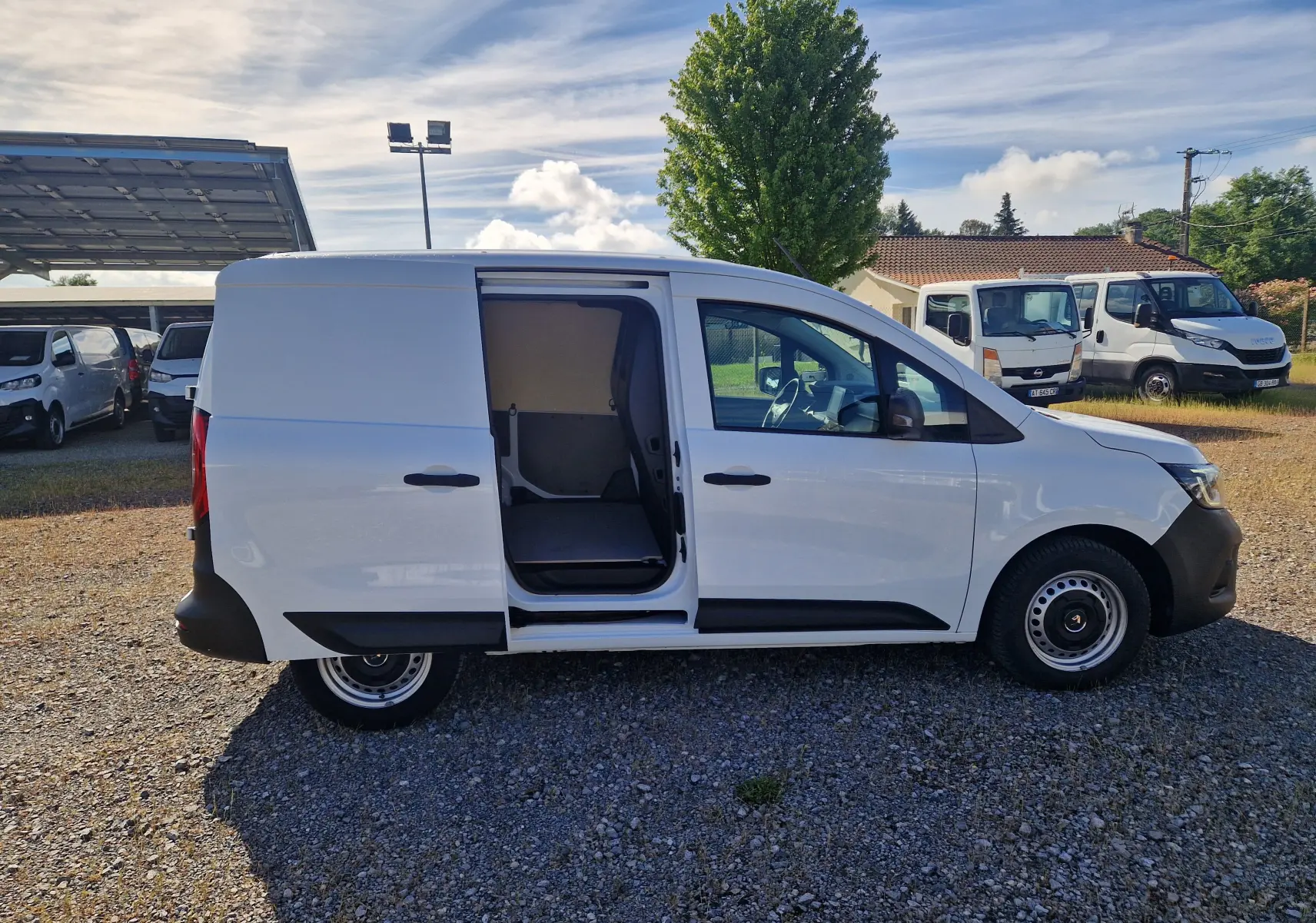 Renault Kangoo blanc vue de profil droit avec porte coulissante ouverte sur un utilitaire 2023.