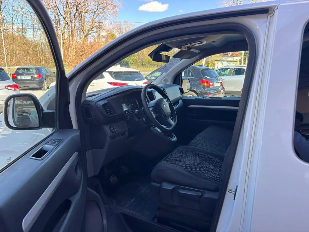 Vue intérieure côté conducteur du Peugeot Expert Fourgon blanc 2018, montrant le tableau de bord et les sièges avant.