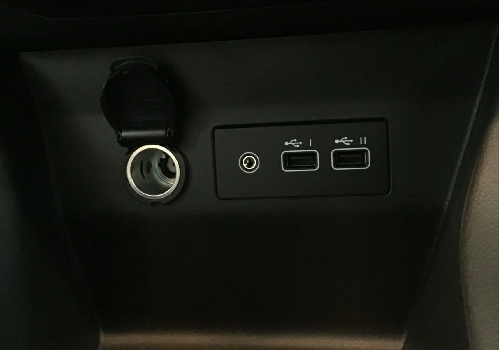 Prise allume-cigare ouverte et deux ports USB visibles sur la console centrale d'une Renault Clio V gris schiste.