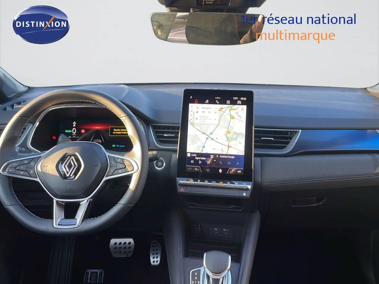 Vue intérieure du tableau de bord Renault Captur E-Tech hybride 2025 avec écran tactile central et volant multifonction noir.
