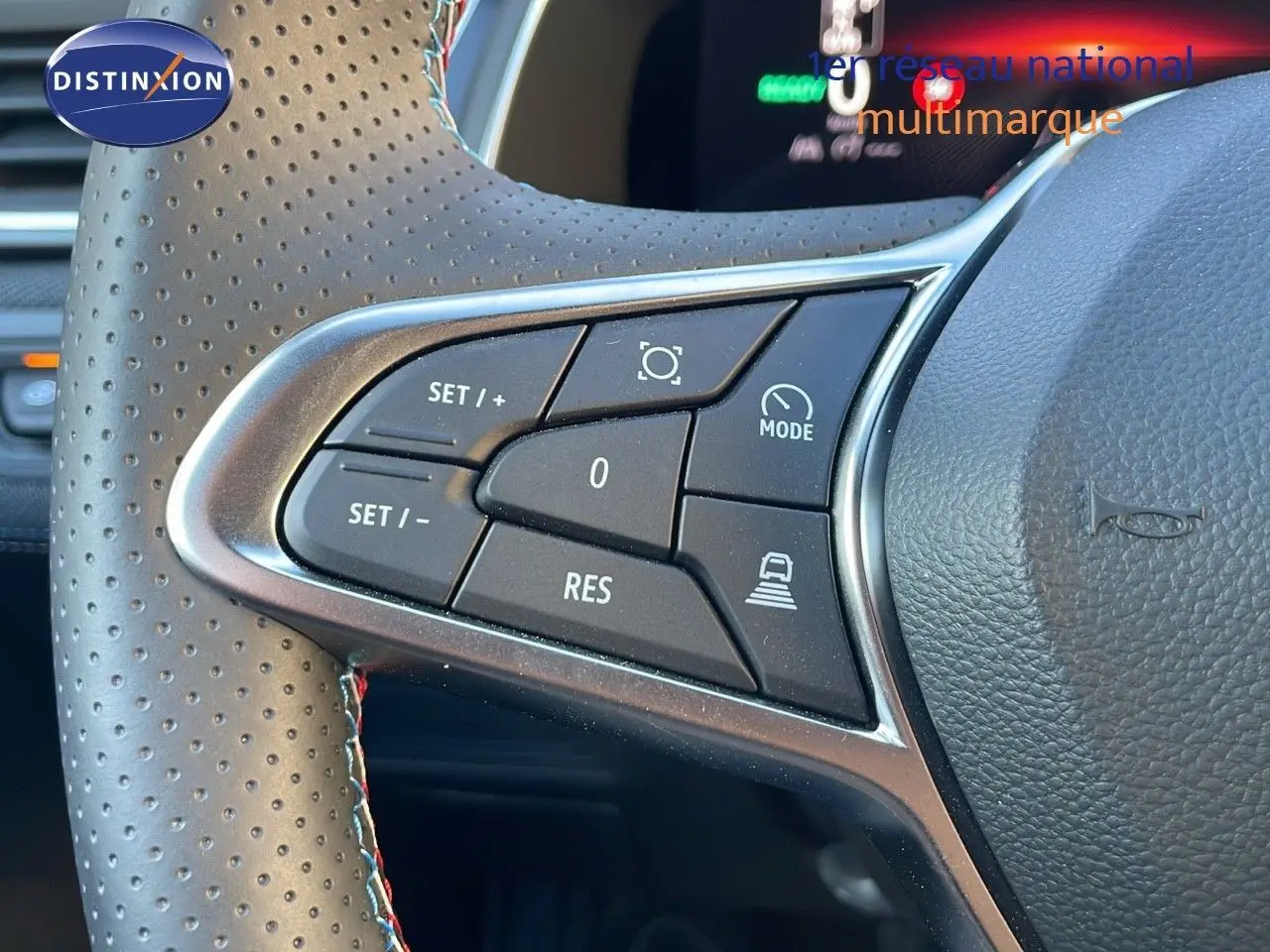 Gros plan sur les commandes au volant en cuir perforé du Renault Captur E-Tech hybride 2025, finition Esprit Alpine.