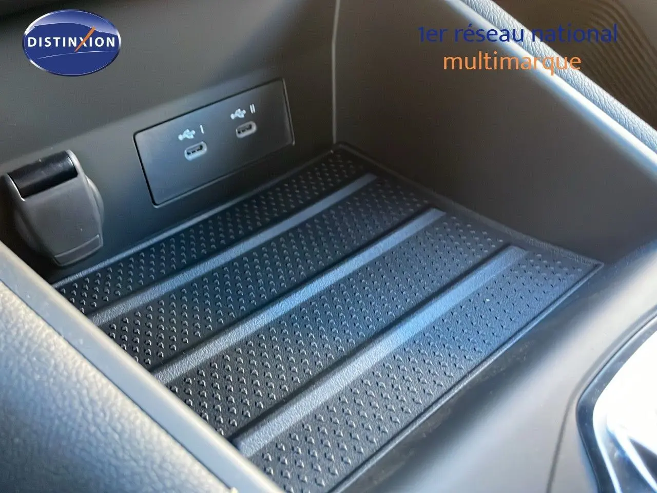 Gros plan sur la console centrale du Renault Captur E-Tech hybride 2025 avec ports USB et surface antidérapante noire.