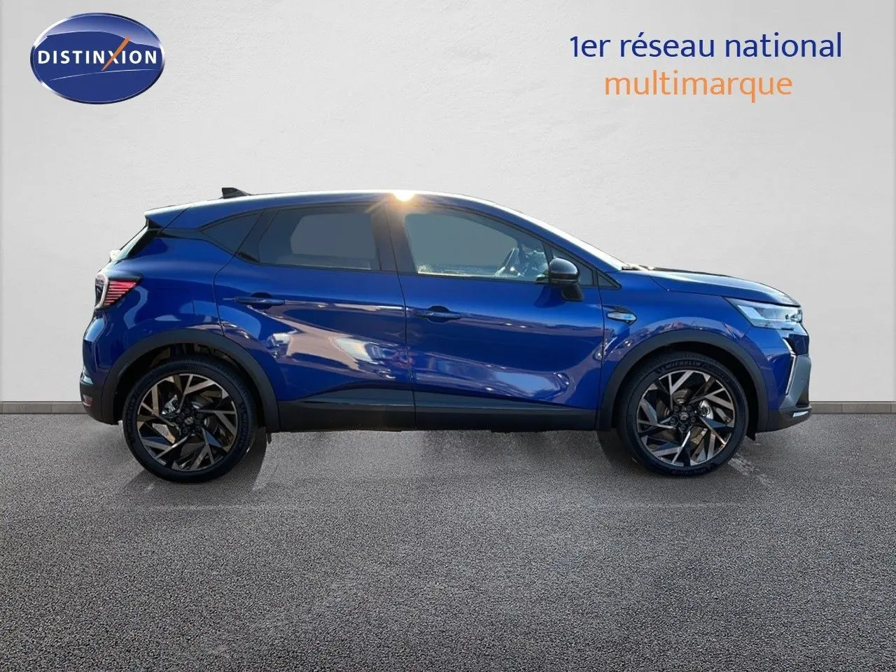 Profil côté gauche du Renault Captur E-Tech hybride 2025 en bleu Iron Metal avec jantes noires bicolores.