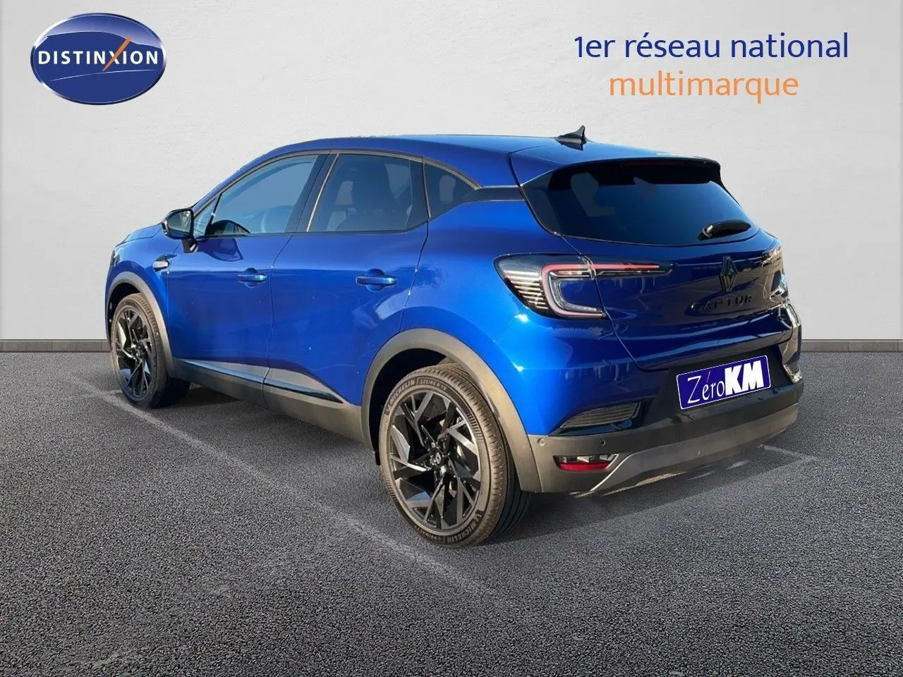 Renault Captur E-Tech hybride bleu Iron Metal en 3/4 arrière droit avec jantes noires et feux LED distinctifs.